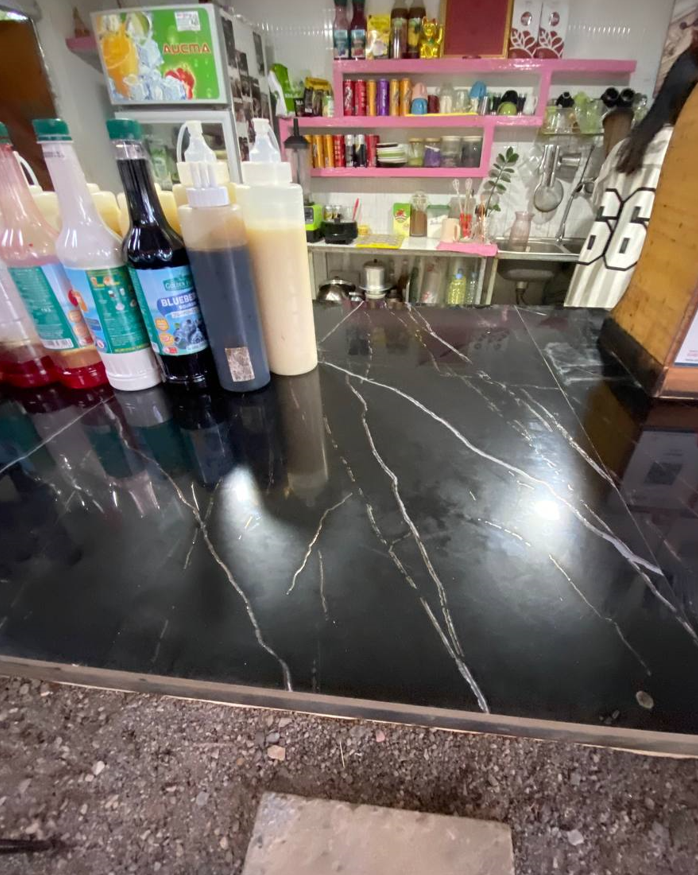 Clean coffee shop counter with organized syrup bottles and ingredients ready for customers