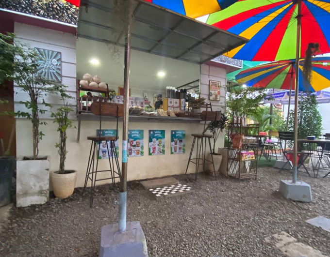 Preparing the coffee counter at The Press Day Coffee kiosk with shutters open and snack rack display.